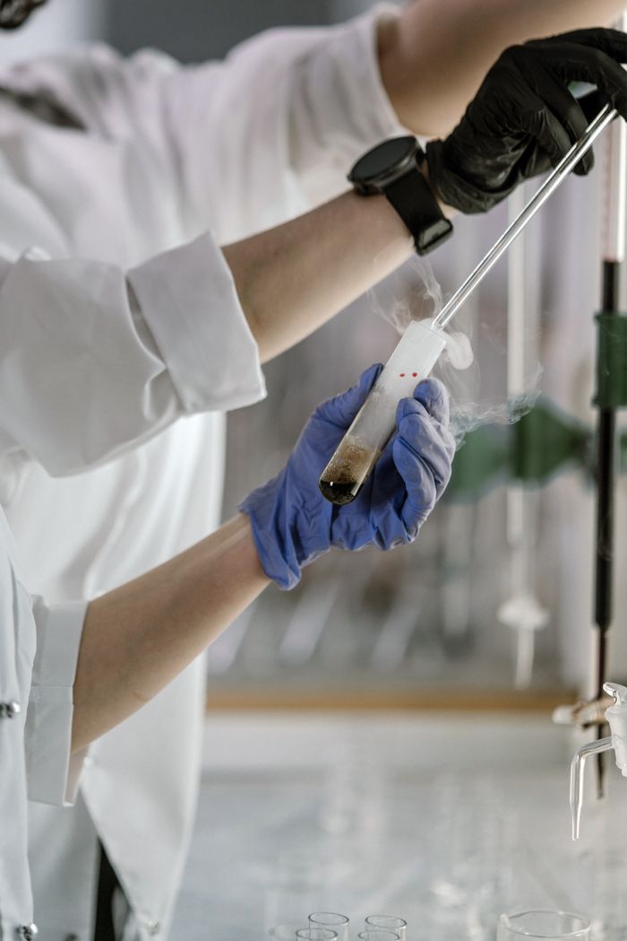 Lab researchers using pipettes for a chemical experiment with colorful liquids.